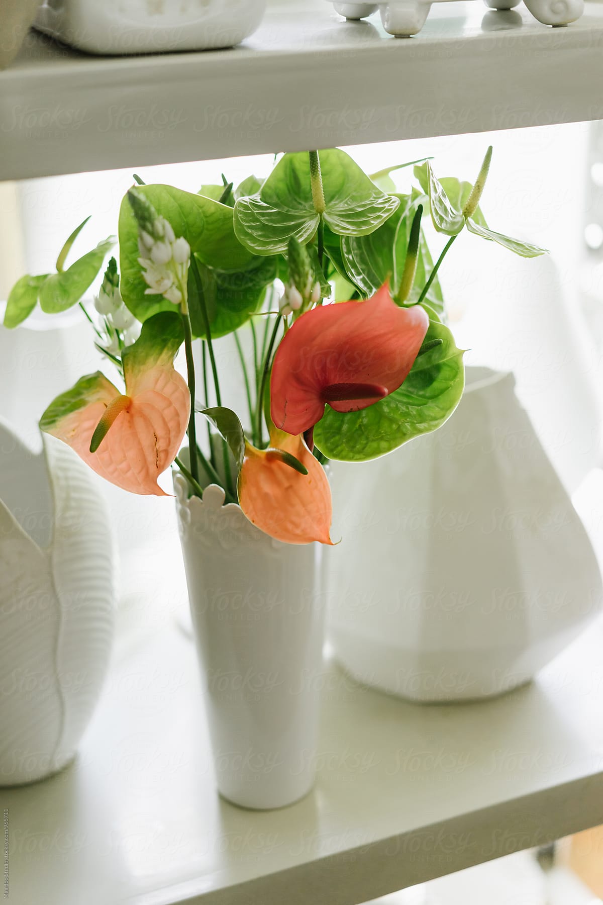 Shelf with empty vases and bouquet of flower