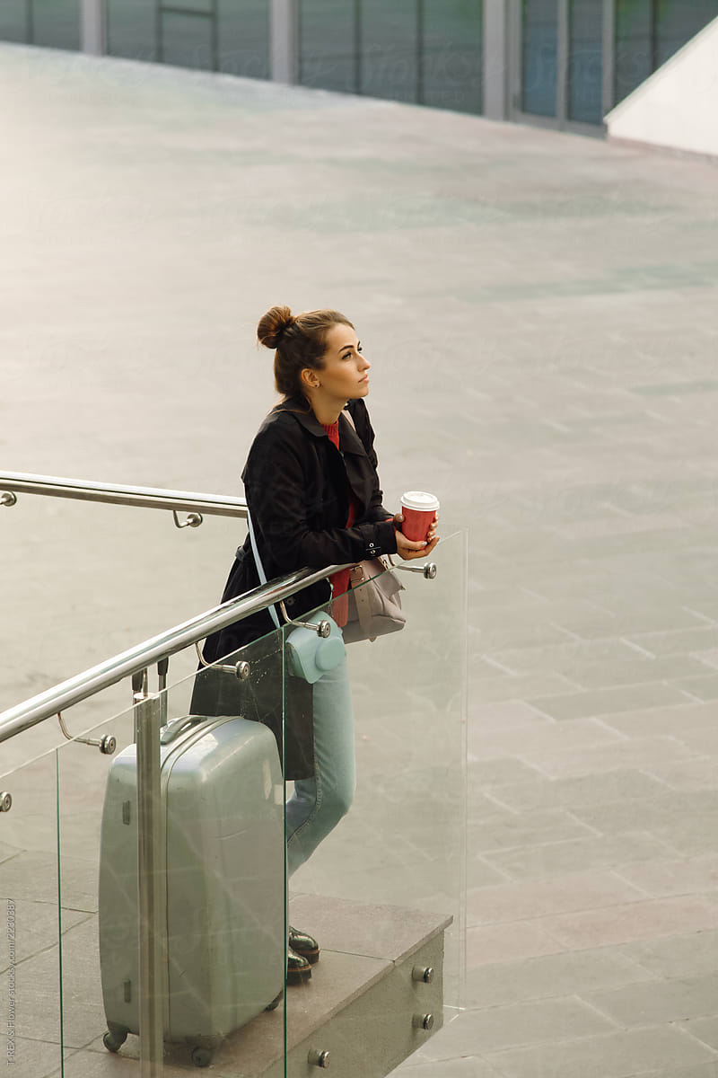 Young female with cup waiting for flight at airport