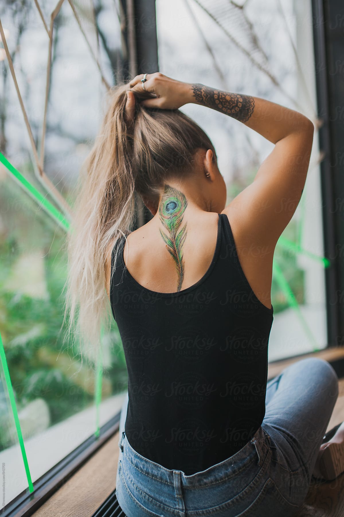 Girl With A Peacock Feather Tattoo by Stocksy Contributor Irina