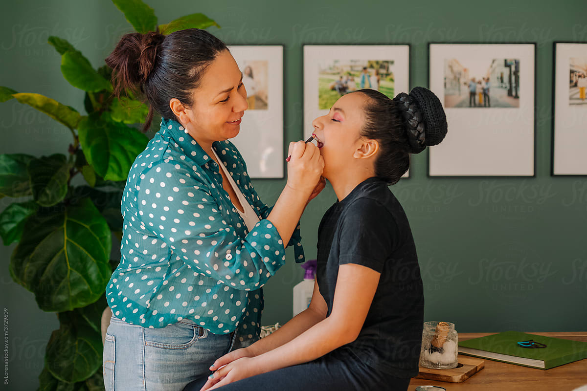Mother applying makeup to her daughter