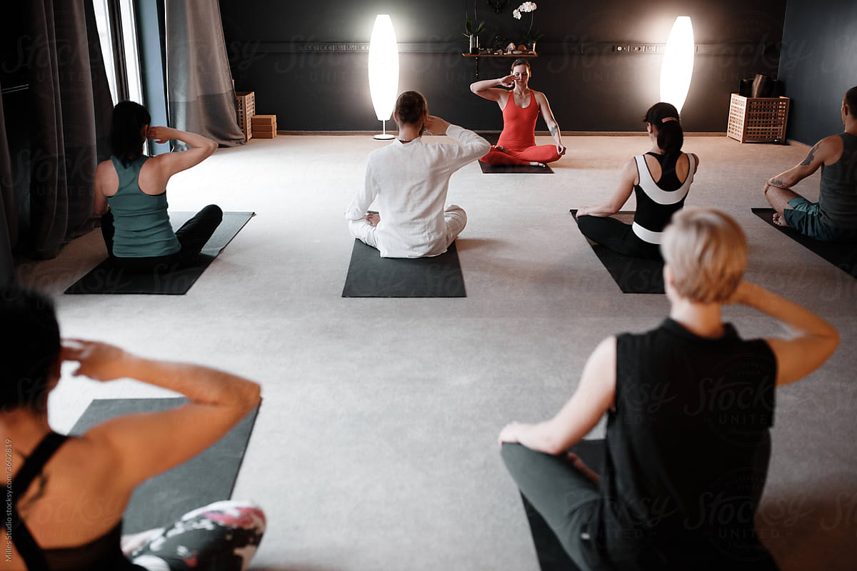Group and yoga couch meditating together