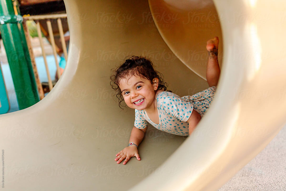 Happy young girl in tube slide