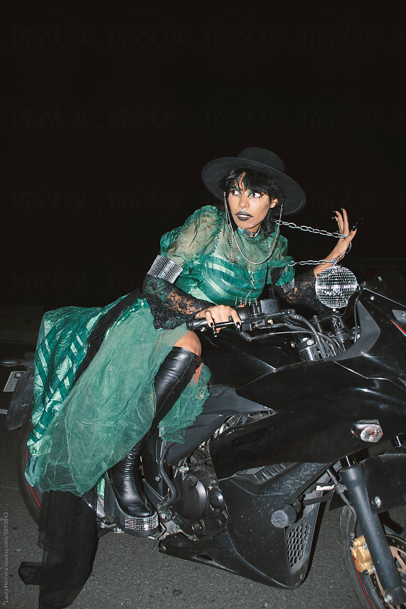 Alternative disco goth woman riding a motorcycle