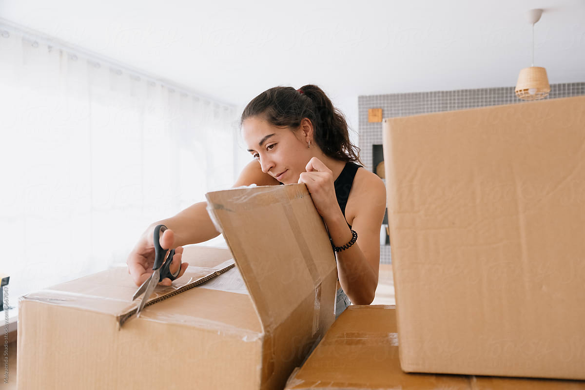 Woman opens moving boxes