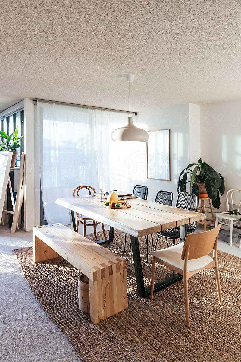 Dining and living room with table plants, and hanging light pendant