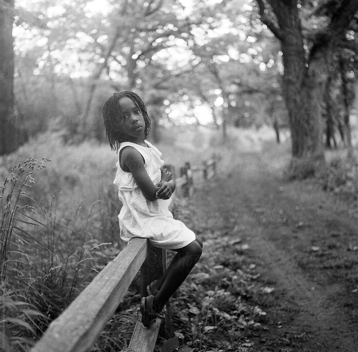 African American Girl Sitting On A Fence In A Forest By Stocksy Contributor Gabi Bucataru