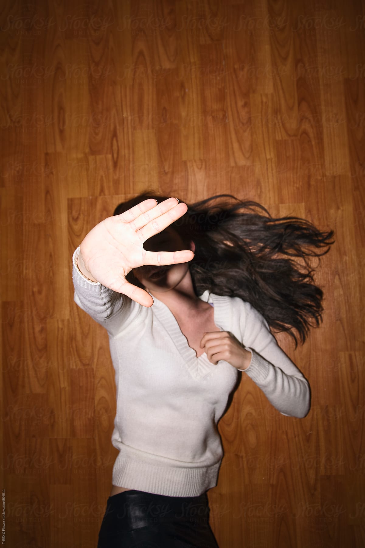Young woman hiding her face from camera with hand