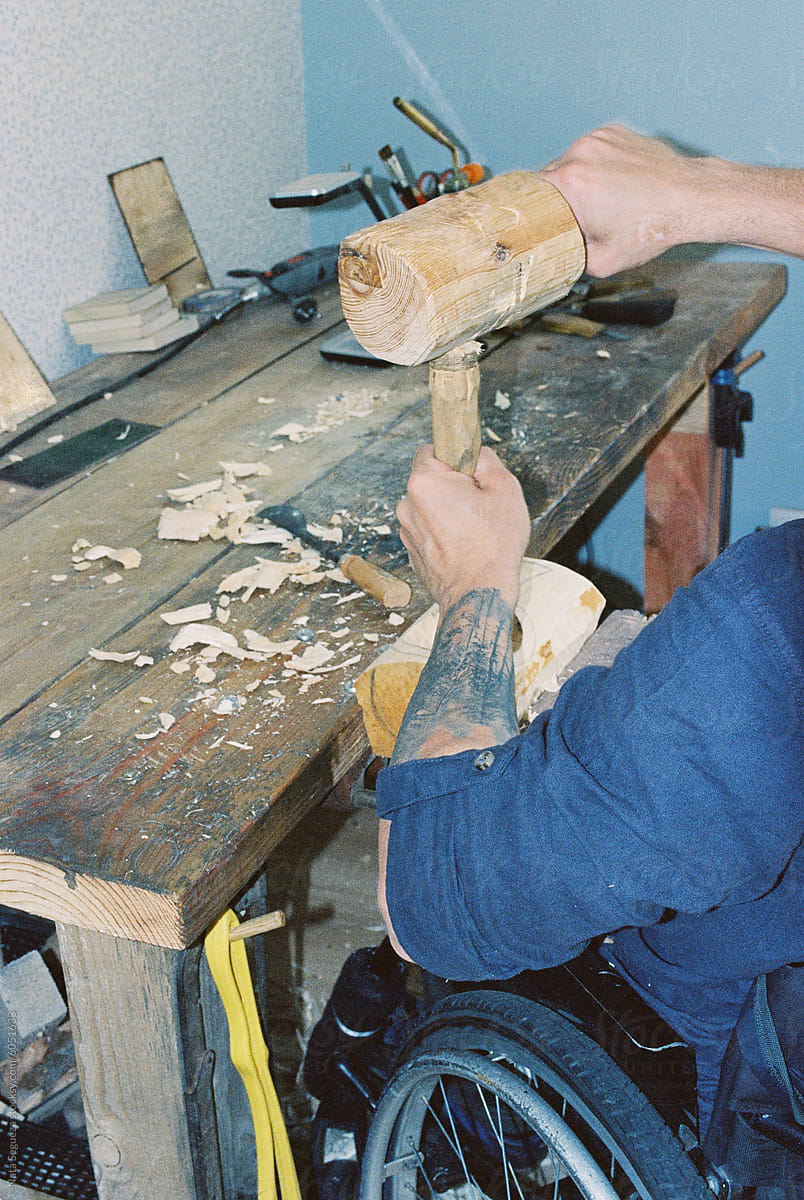 A master woodcarver in a wheelchair at home