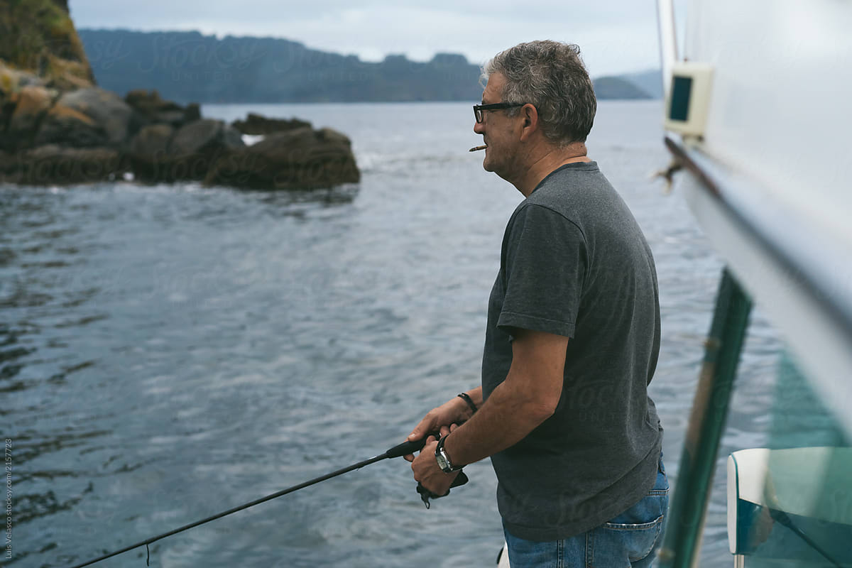 Man Fishing With Fishing Rod On A Boat.