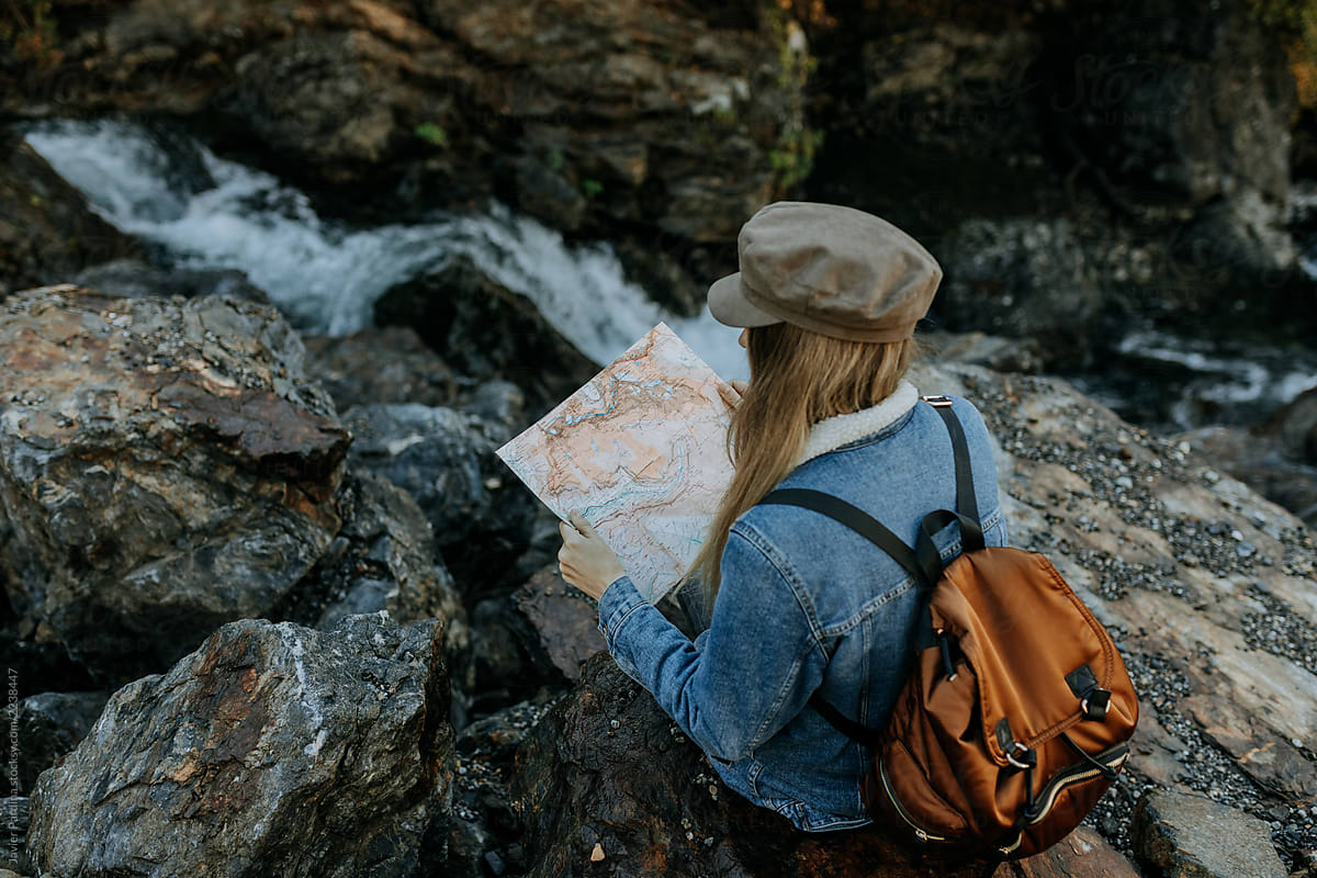 woman with a map exploring the mountains