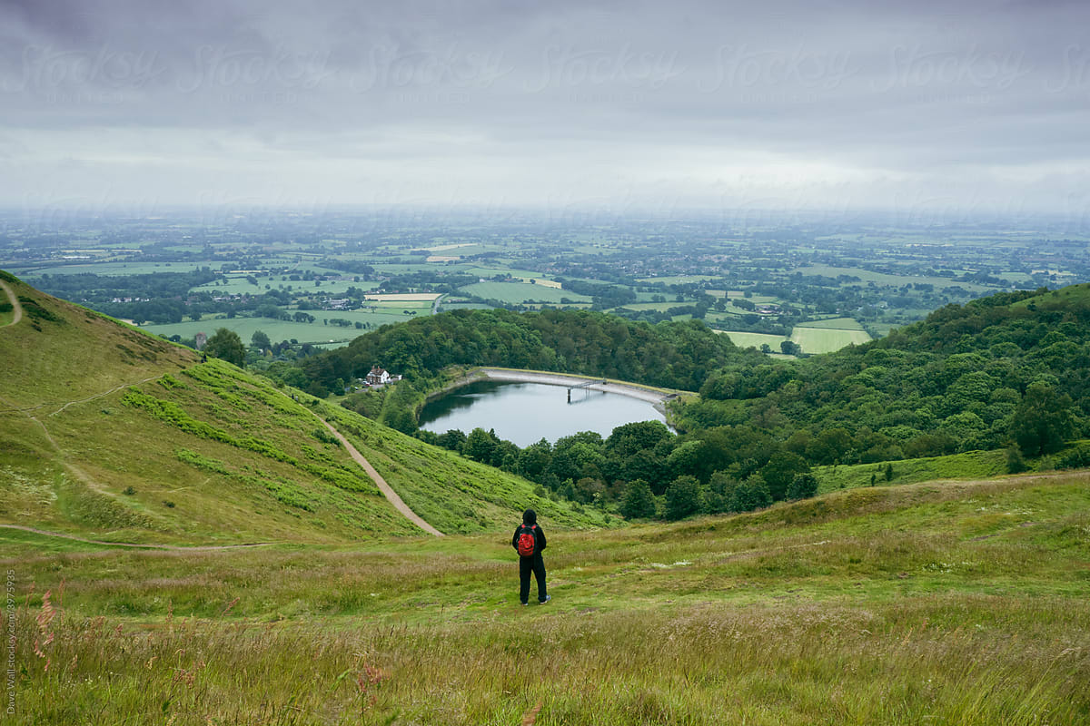 A hiker with rucksack, looking out on the countryside