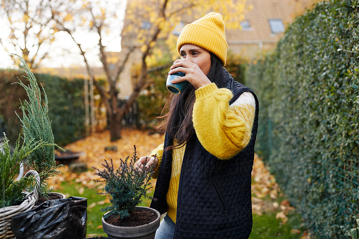 Woman drinking a coffee while gardening
