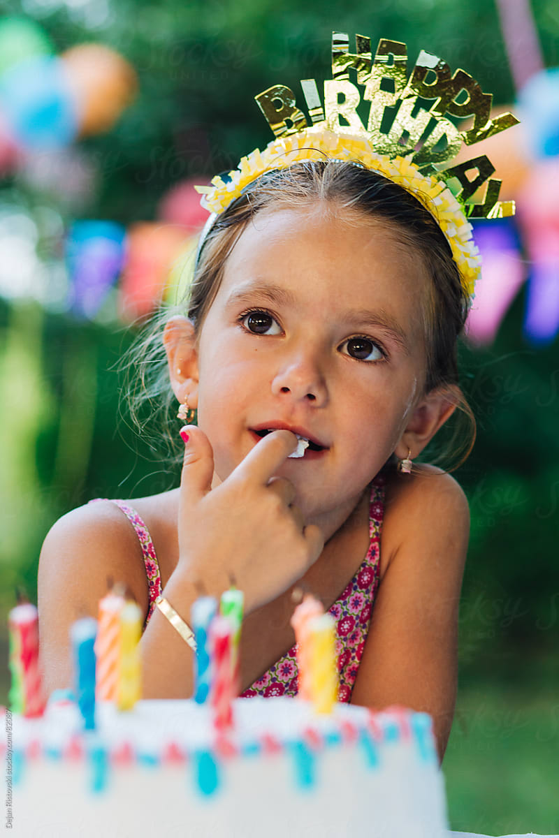 Child tasting birthday cake