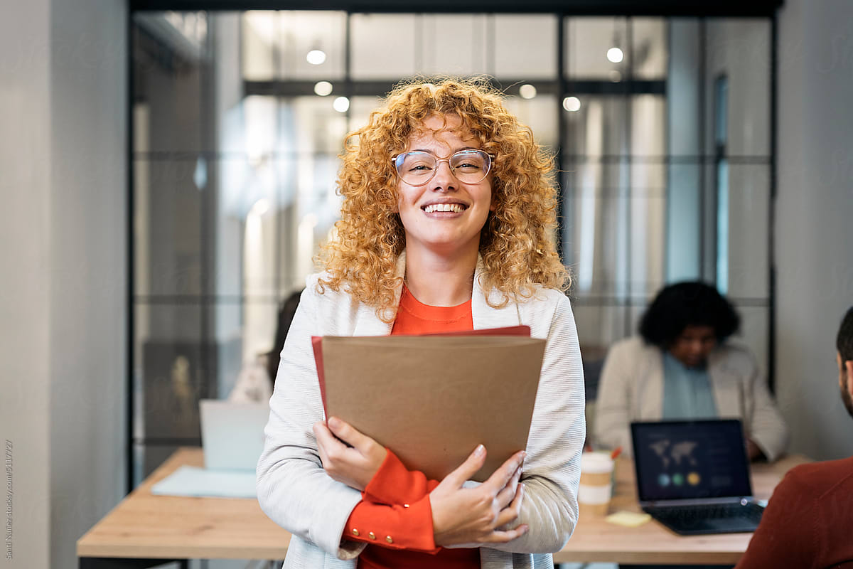 Cheerful woman with clipboard in office