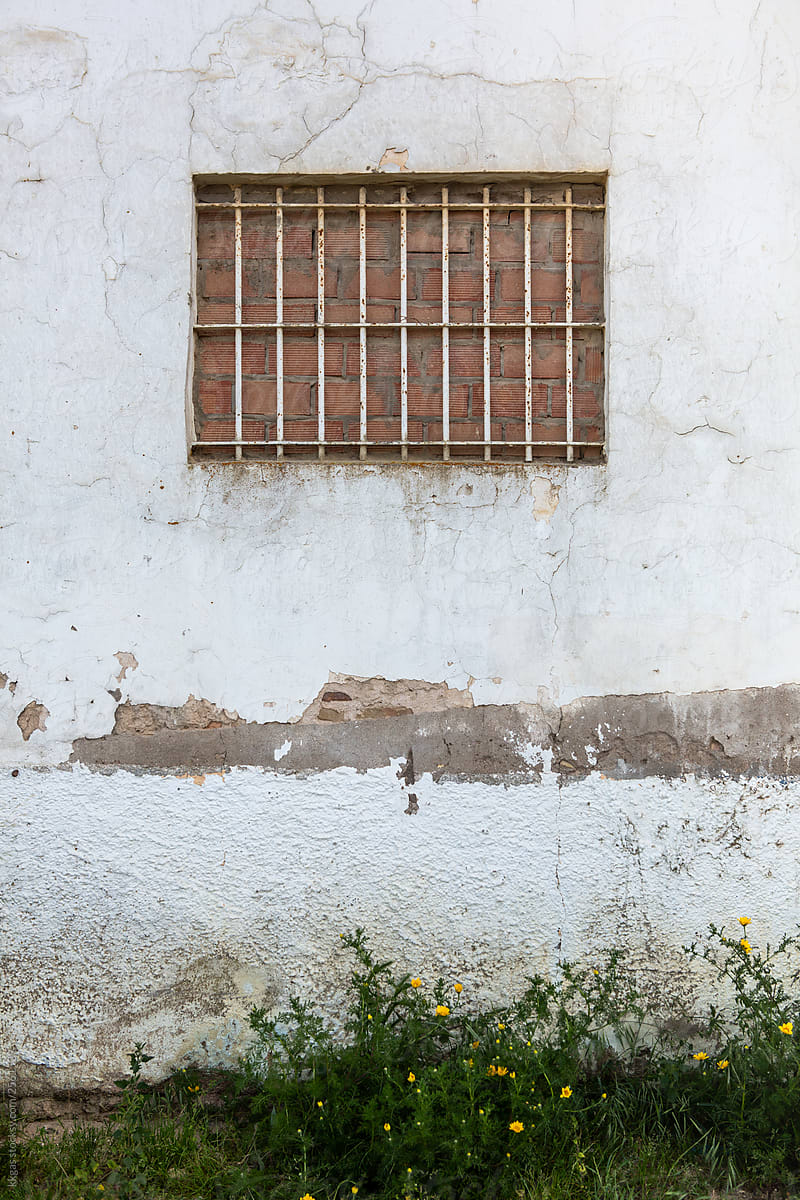 A bricked up window with security bars