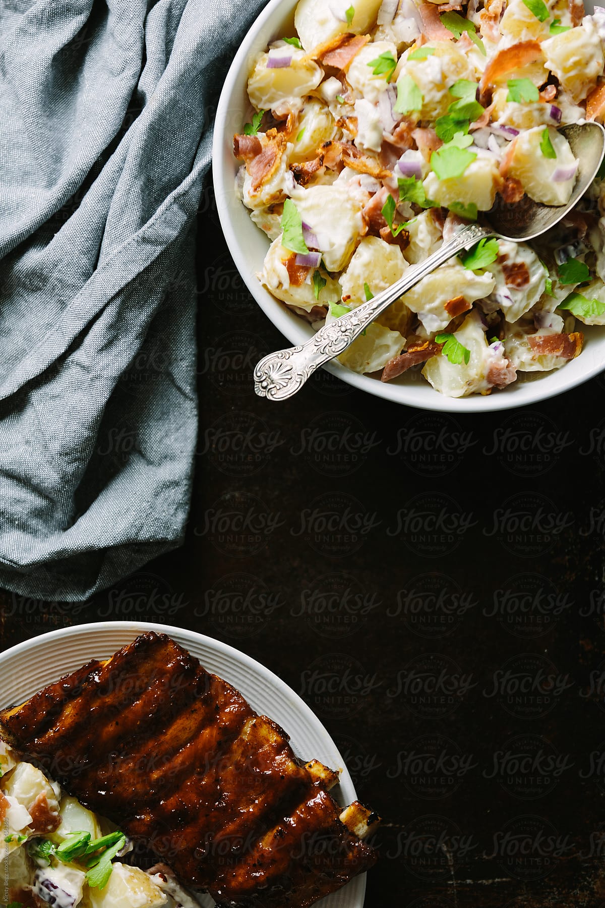 Bowl of potato salad with plate of bbq ribs