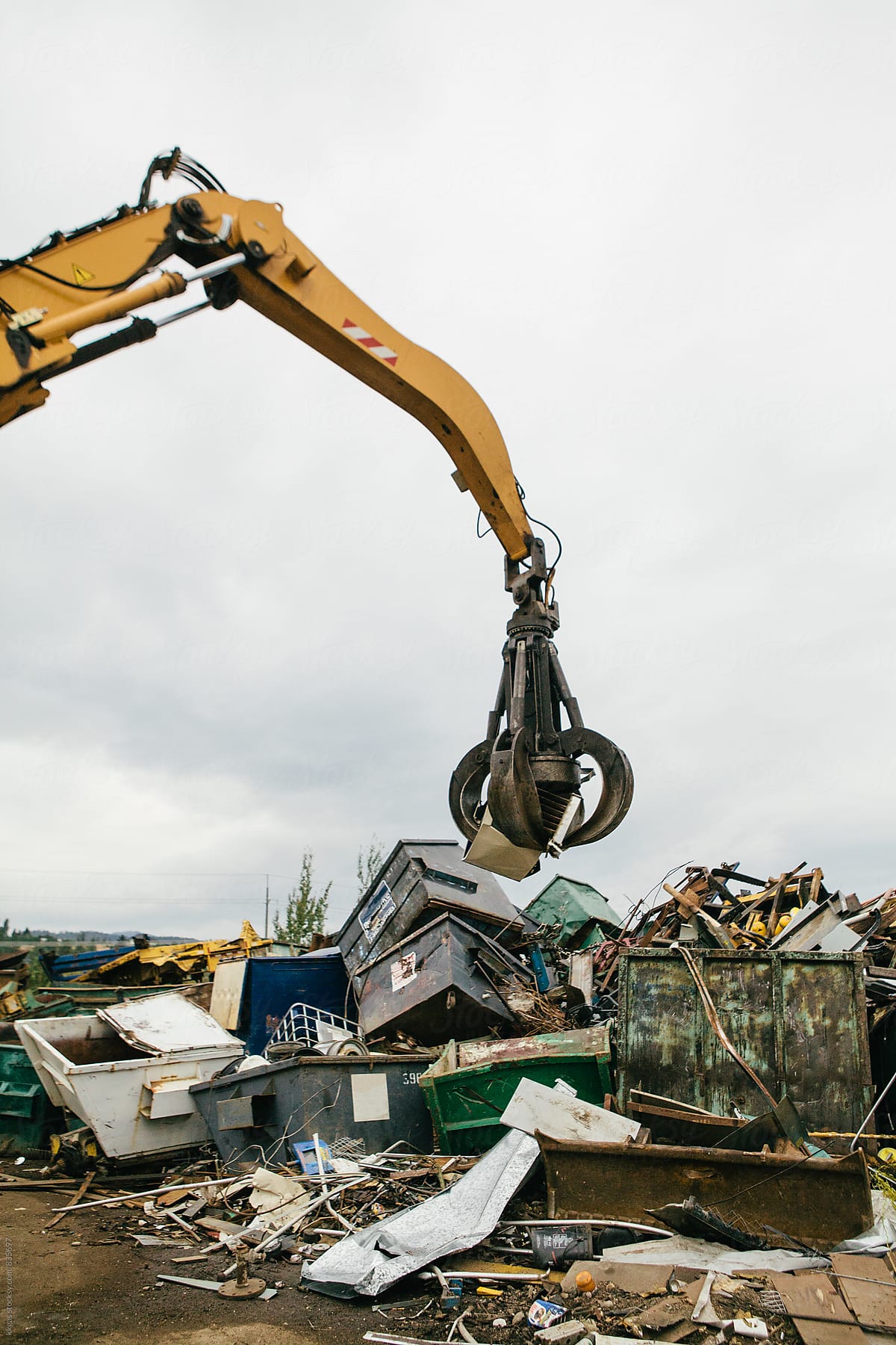 Excavator sorting out metal for recycling at a recycling centre