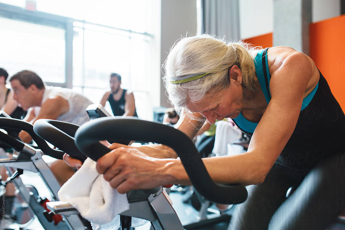 Older caucasian woman working hard during spin cycle class