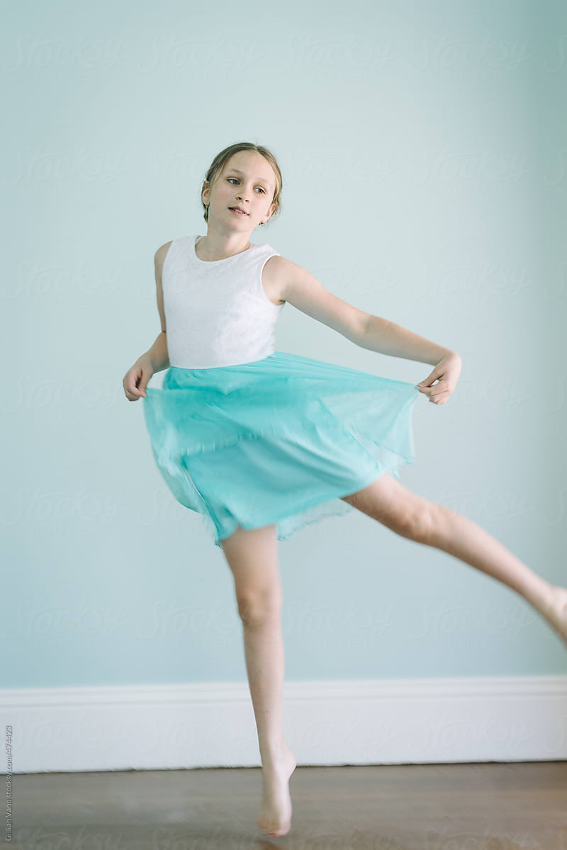 tween girl jumping in a floaty blue dress