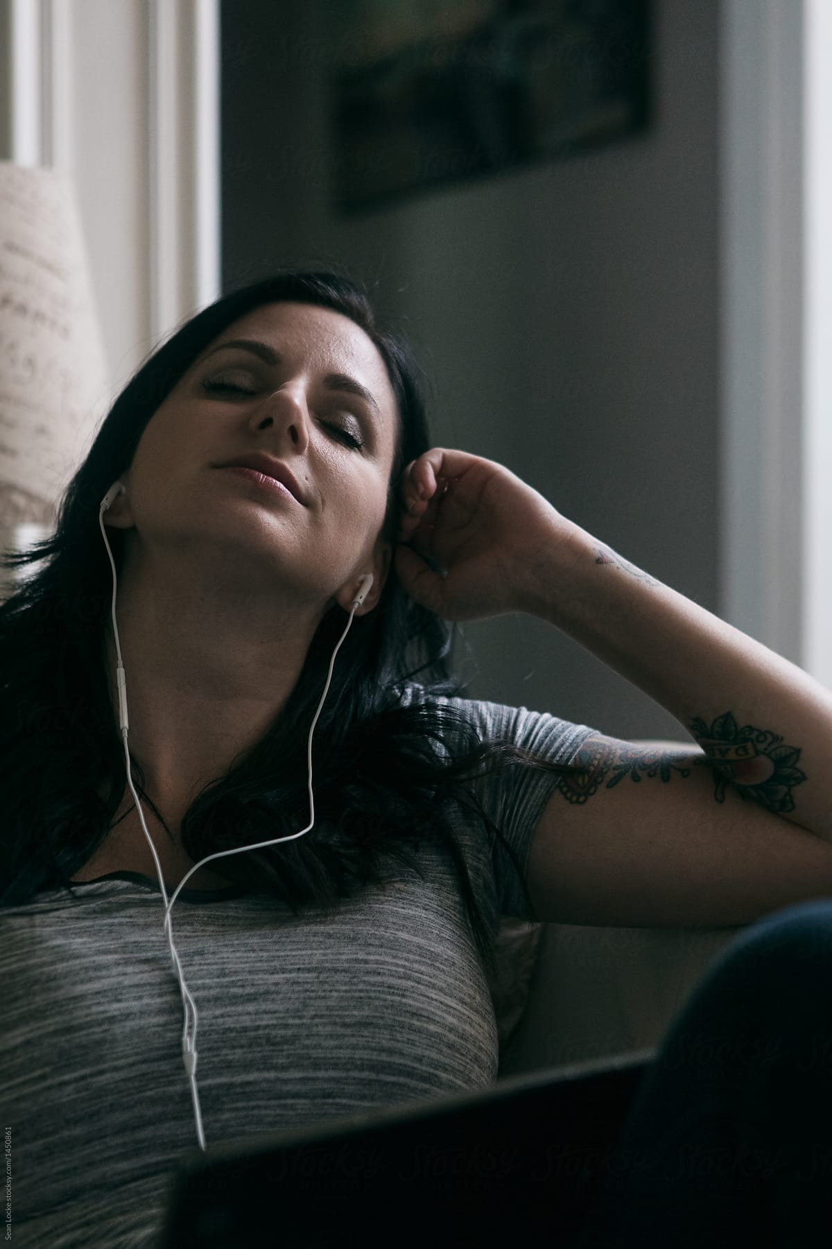 Tunes: Woman Relaxes On Couch Listening To Music