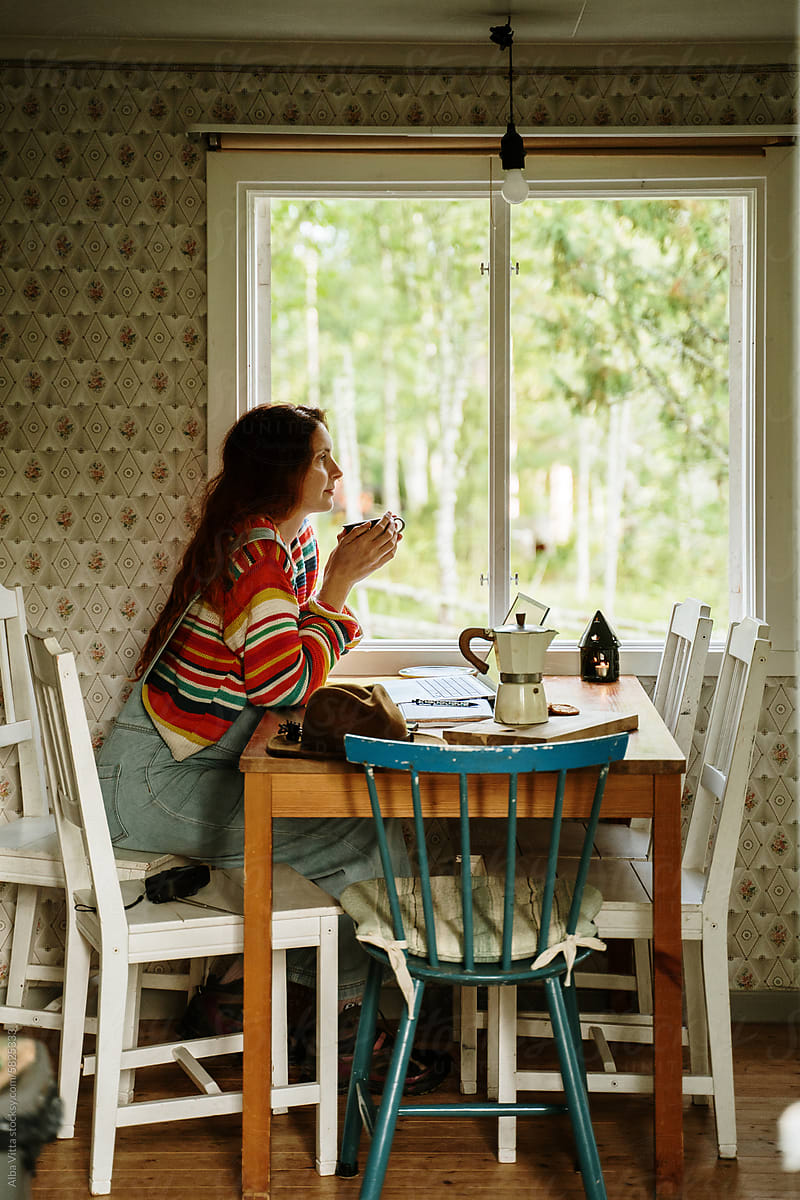 Woman drinks coffee at cabin