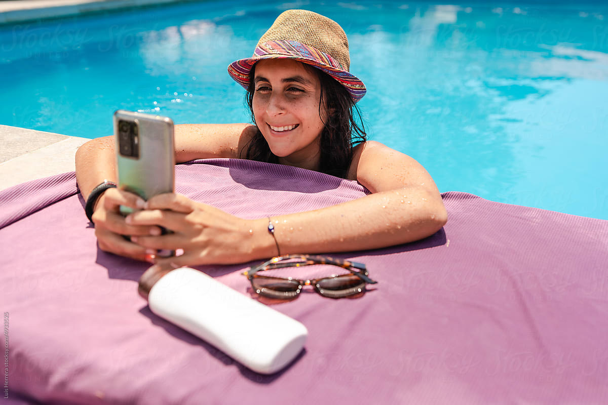 woman using her phone at a swimming pool
