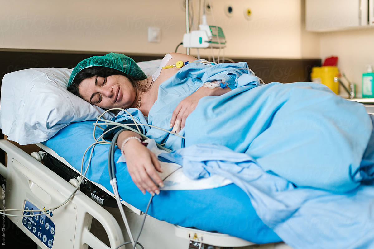 Cheerful pregnant woman in hospital bed during birth