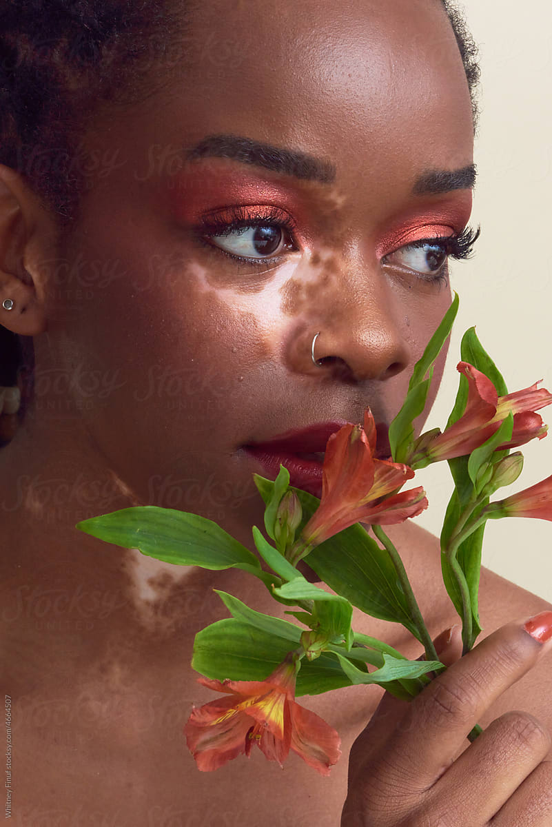 Peaceful Black Lady Model Holding Flowers and Gazing Off Screen