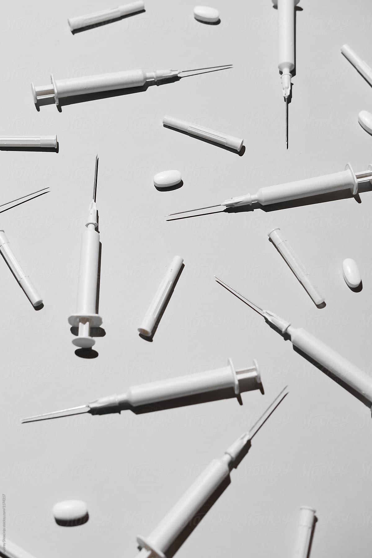 Blanc hypodermic needles adn pills on white background.