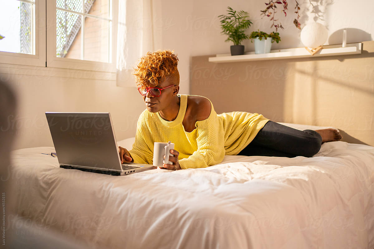 Black Woman With Laptop On The Bed.