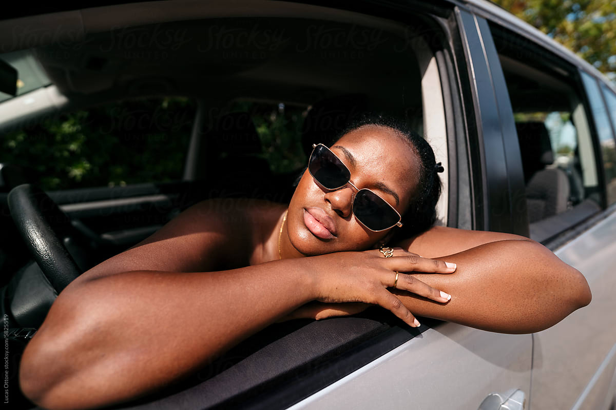 Black woman resting inside car