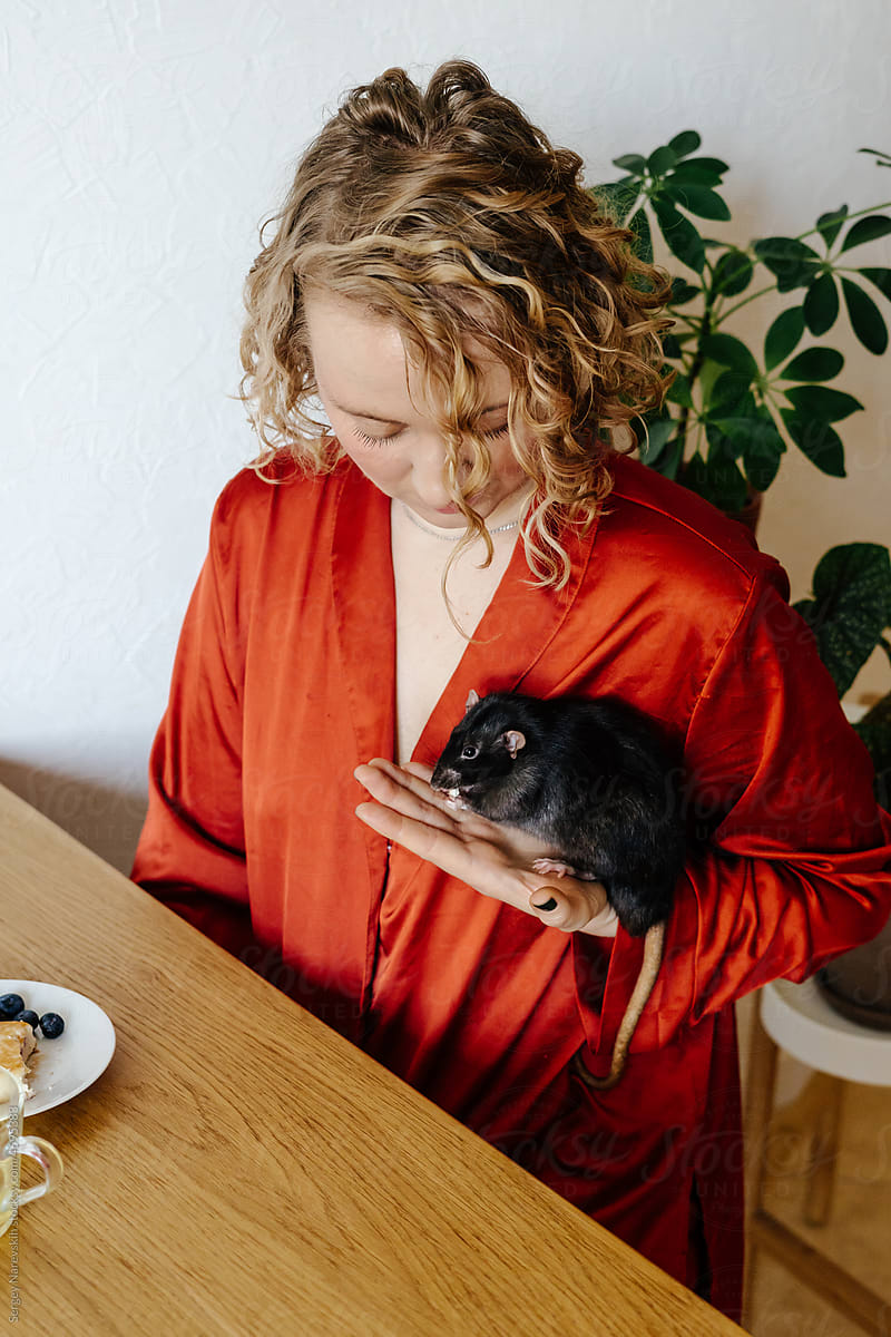 Woman feeding domestic rat from her hands