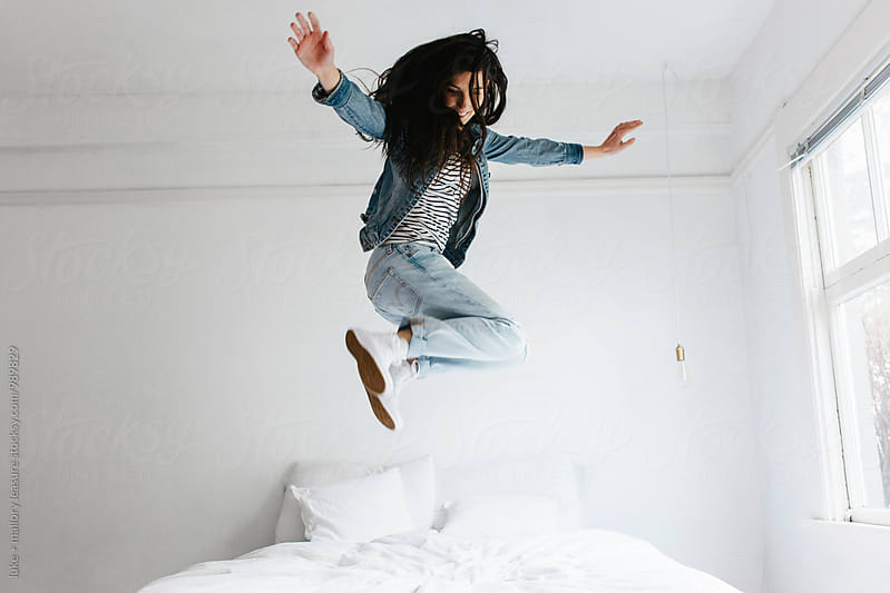 Girl jumping on bed