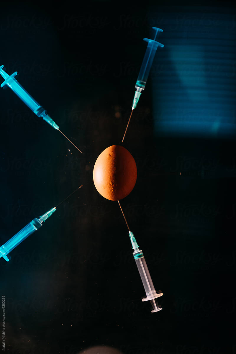 Medical syringes, an egg as a symbol of the whole world.