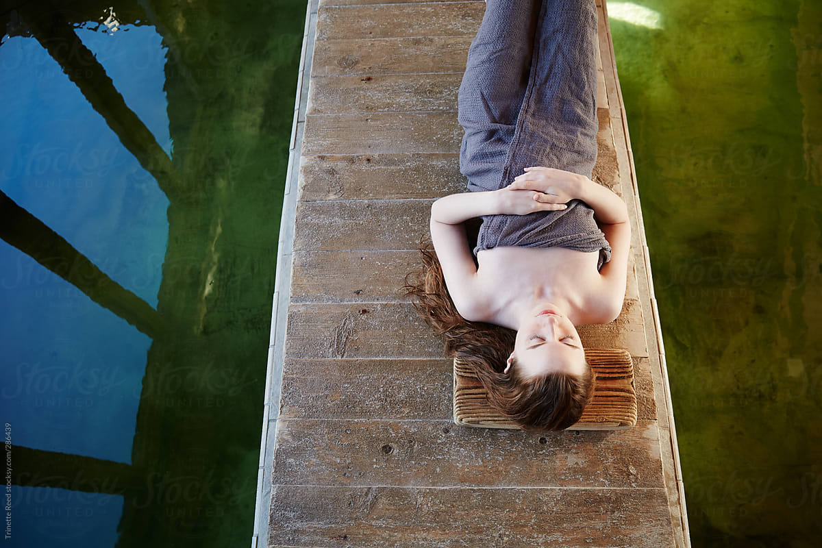 Woman relaxing on wood planks at Japanese hot springs