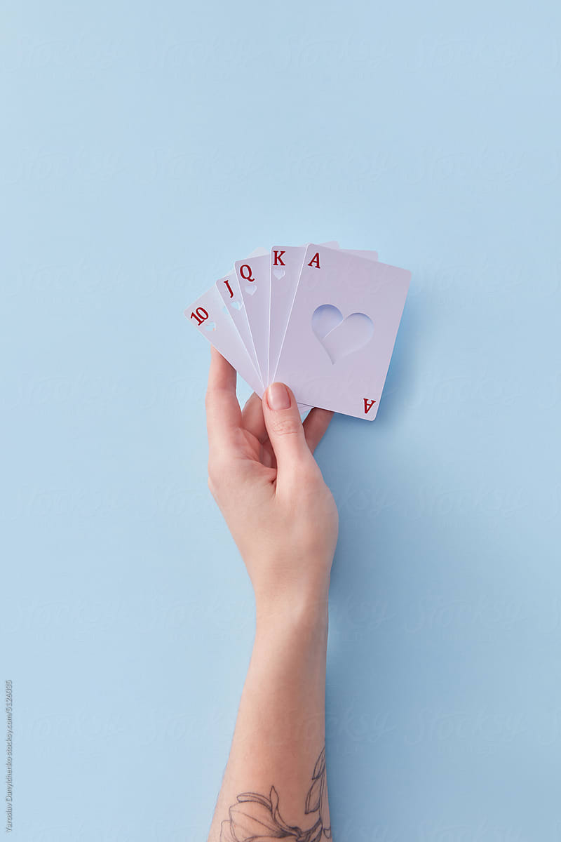 Cards with heart hollow held by woman's hand.