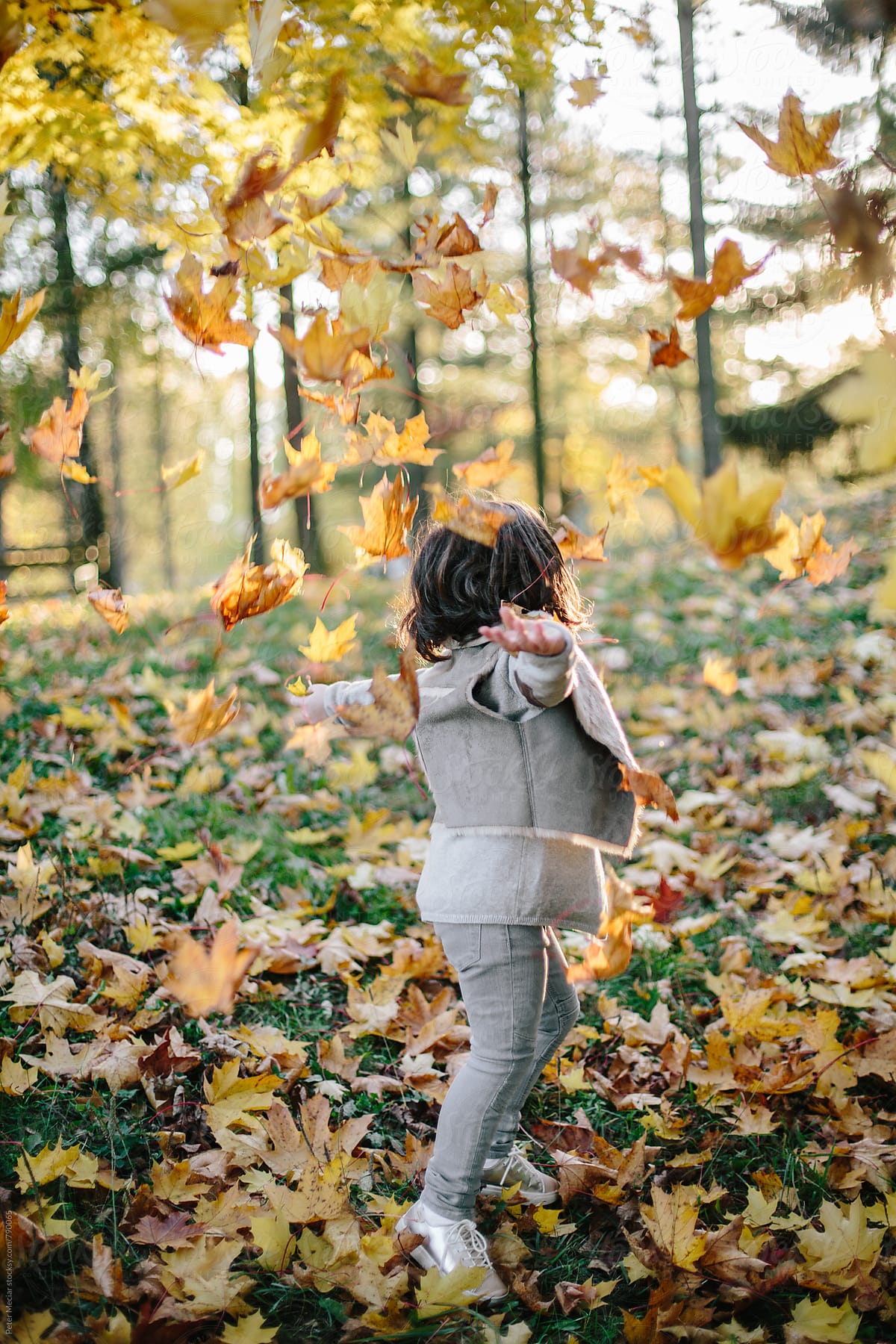 Little girl  is playing in autumn park
