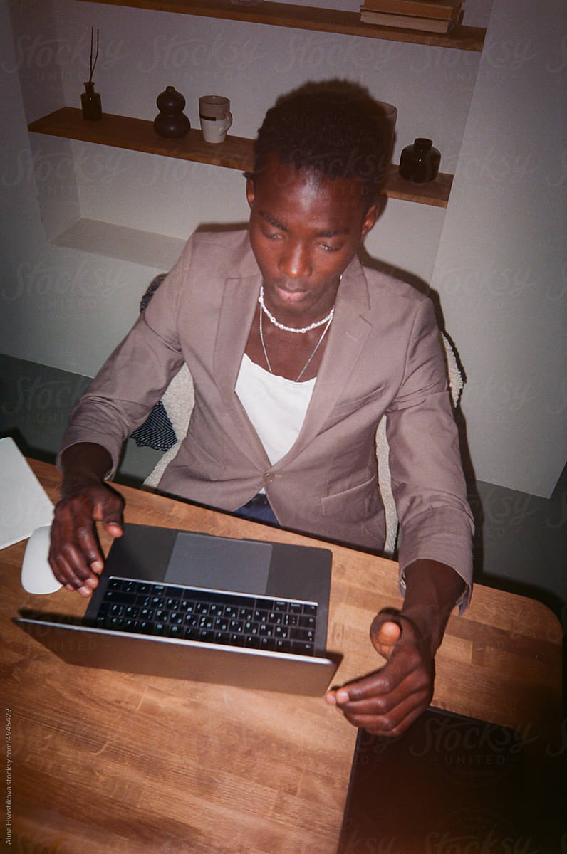 Serious businessman working on laptop at desk