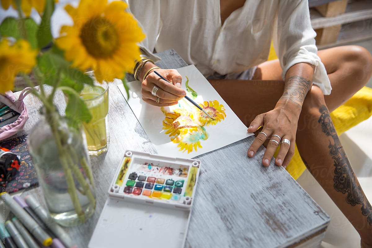 Woman artist drawing sunflowers on paper