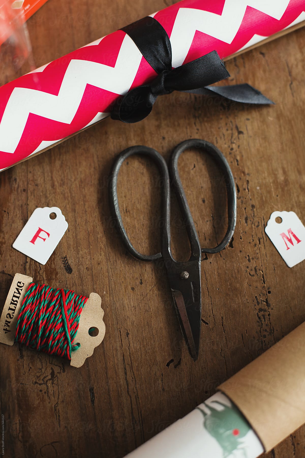 Overhead shot of Christmas wrapping paper, tags, scissors and twines