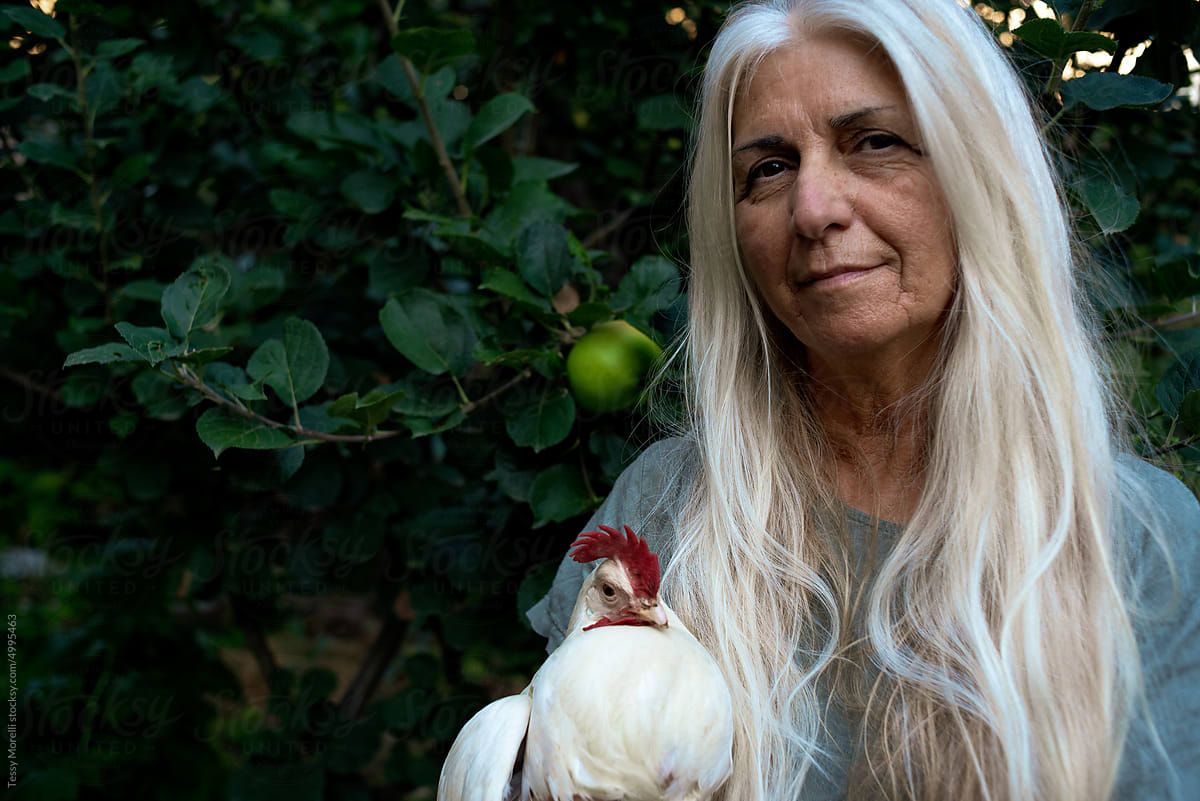 Mature woman with chicken portrait