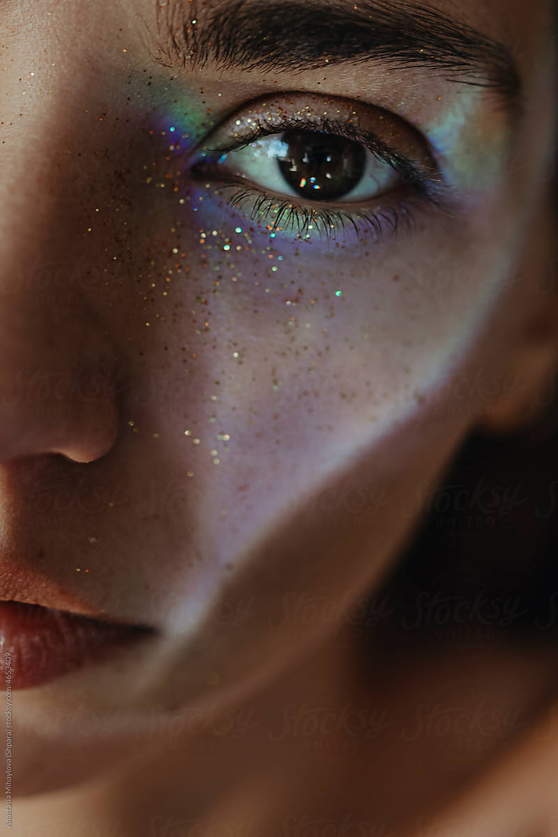 Close Up woman\'s portrait with brown eye with Glitter and rainbow