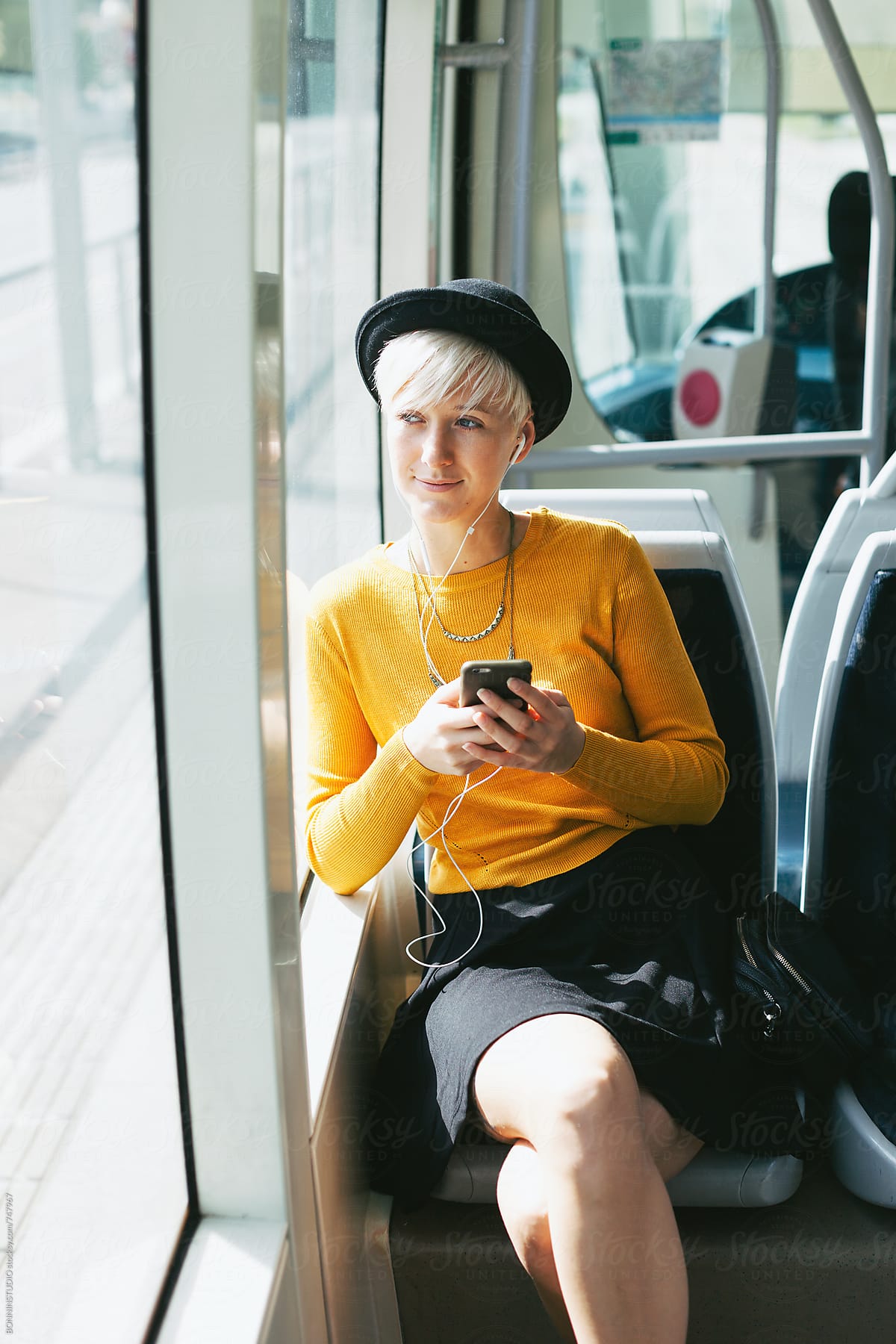 Modern And Chic Woman Using Her Smartphone Sitting In The Train By