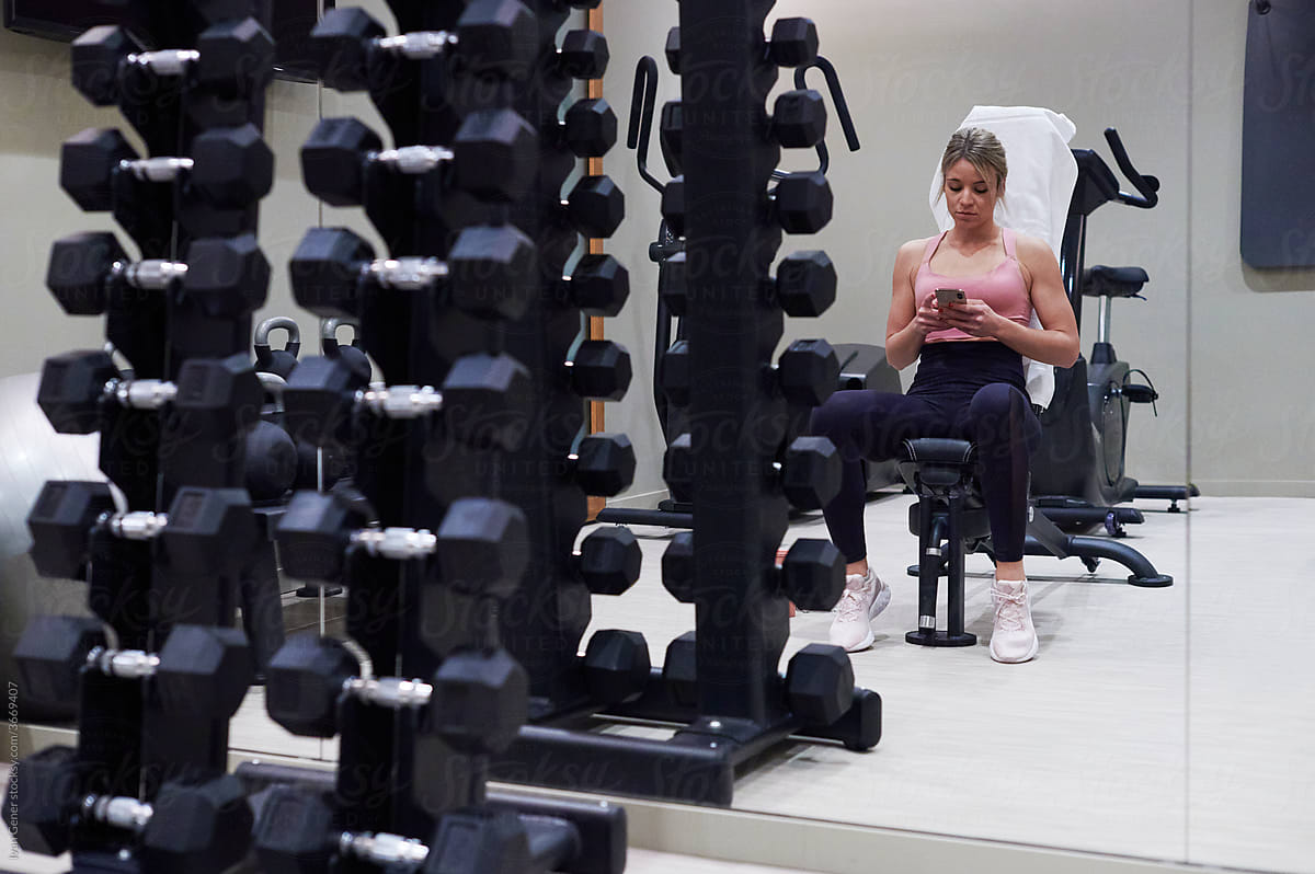 Woman texting after a workout in a gym