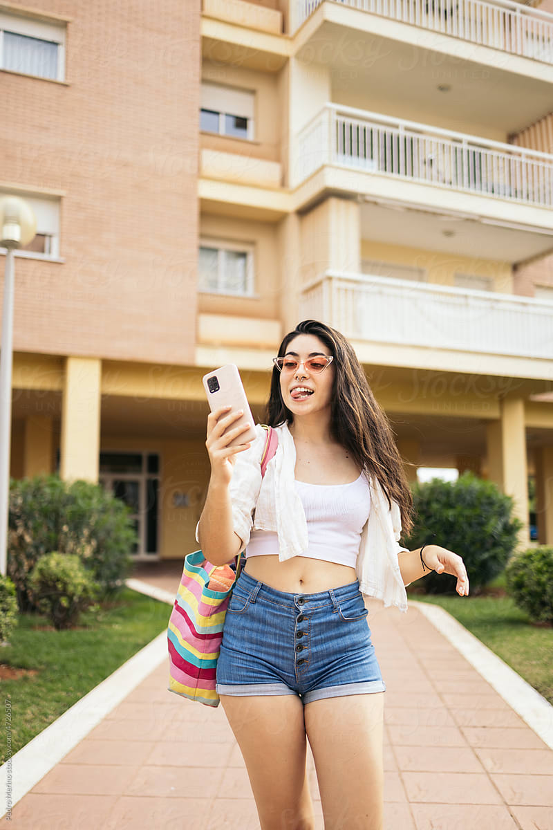 Stylish woman taking selfies with smartphone