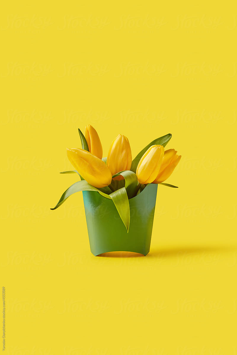 Green paper made box with yellow spring tulips inside