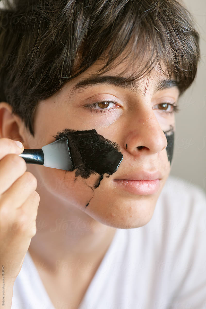 Teen boy applying black mask headshot