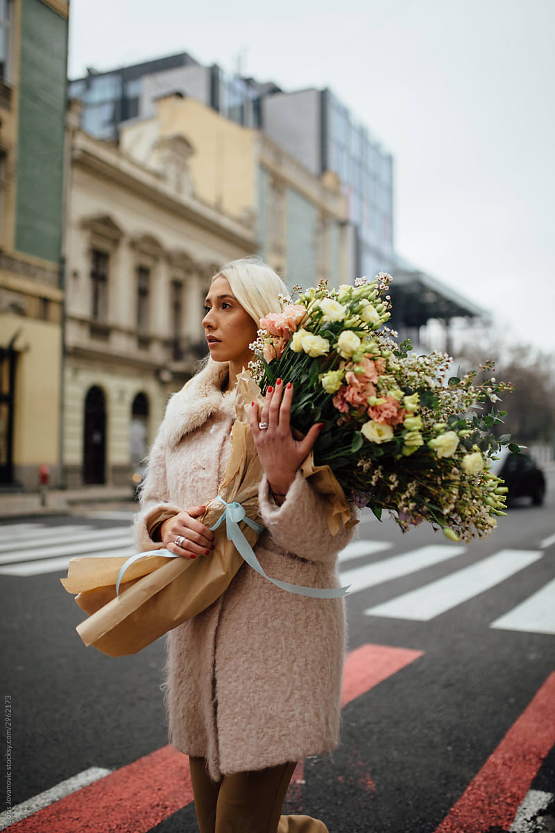 A Portrait Of A Blonde Girl Taking A Stroll While Holding A Beautiful Bouquet