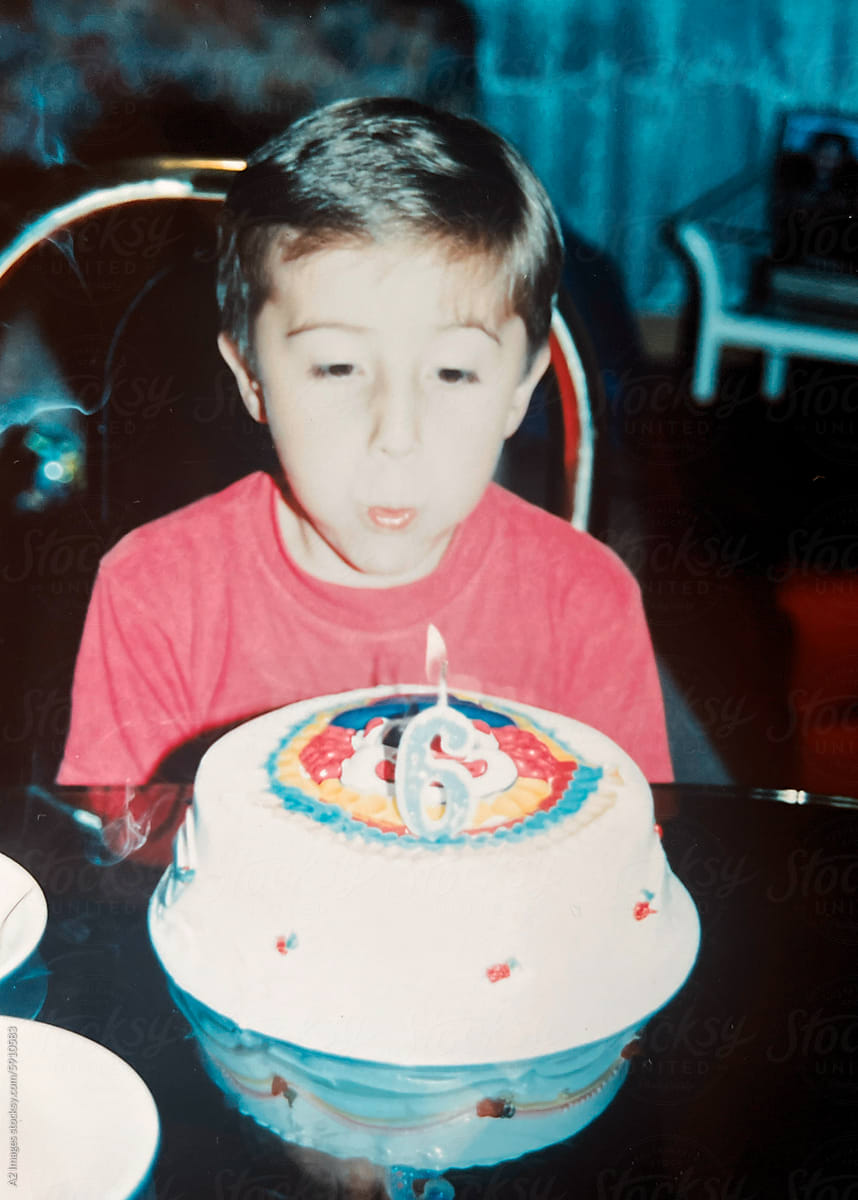 Child blowing out the candle on his birthday cake