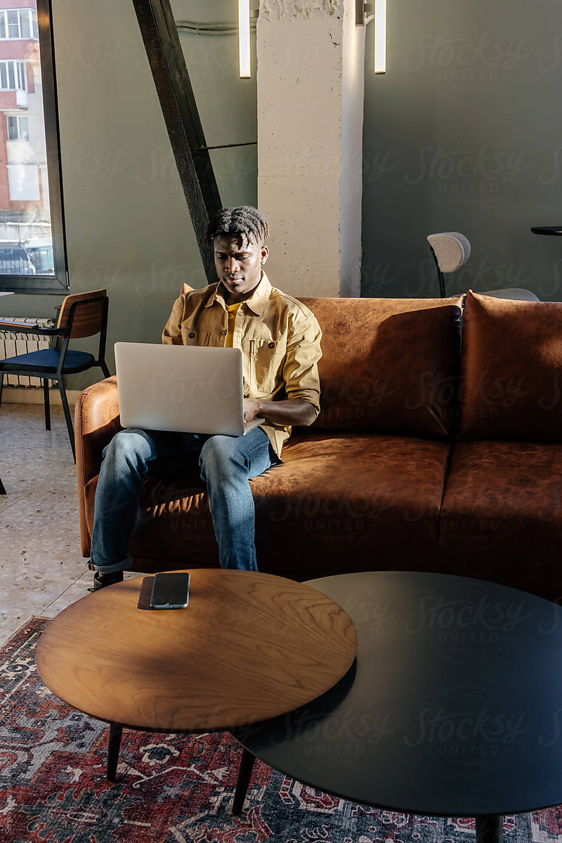 Black man browsing laptop during remote work